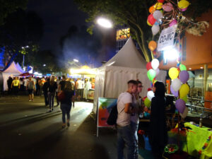 CO-WC info booth at the Lesbian and Gay City Festival by night.