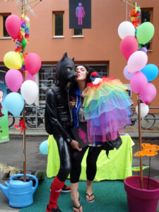 Two people from the Lesbian and Gay City Festival at the CO-WC information booth, the one in the dog costume gets a kiss.