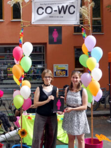 Visitors of the Lesbian and Gay City Festival with the CO-WC sign.