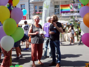 Paul Jonczyk talks to a visitor of the Lesbian and Gay City Festival in front of the CO-WC information booth.