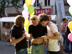 Paul Jonczyk talks to two visitors of the Lesbian and Gay City Festival about the CO-WC flyer.